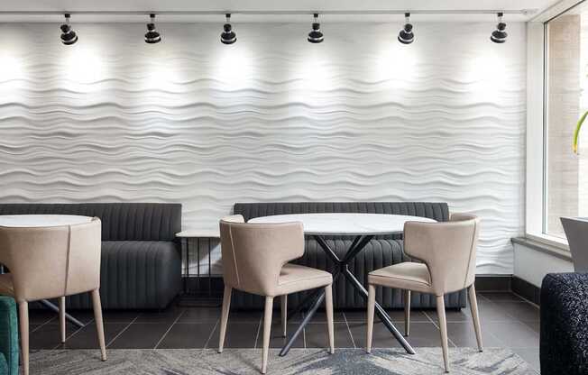 a table and chairs in a room with a white wall