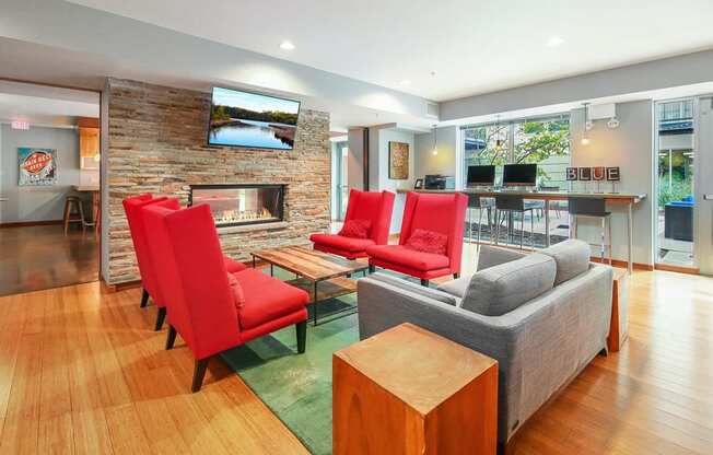 a living room with red chairs and a fireplace