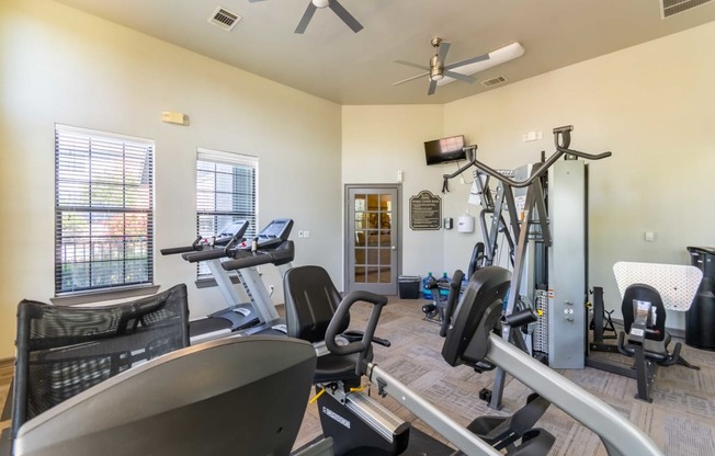 gym with cardio equipment at the whispering winds apartments in pearland, tx