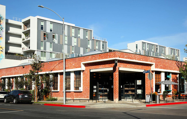 A red brick building with a white car parked in front.