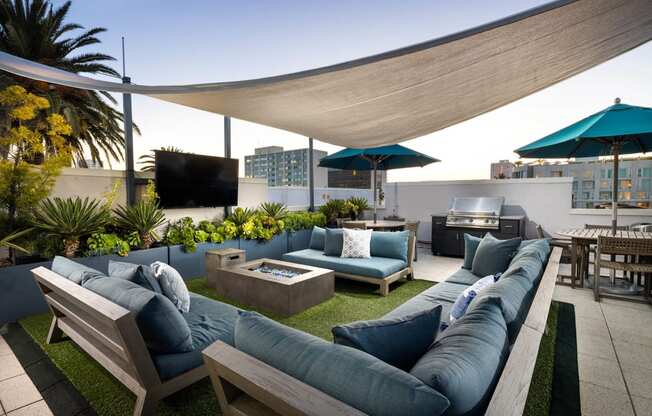 a roof terrace with couches and umbrellas