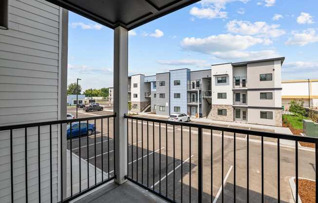 the view from the balcony of an apartment building with a parking lot