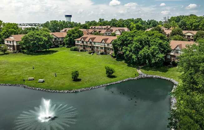 A fountain in the middle of a lake surrounded by houses