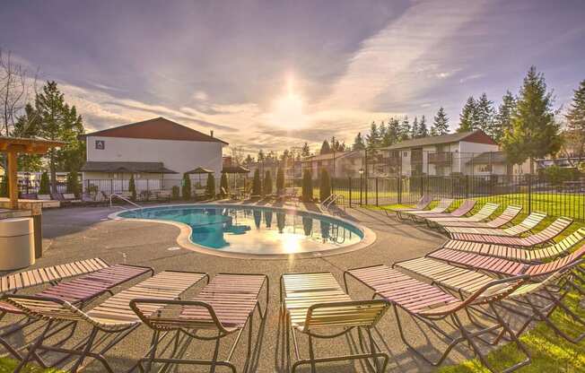 Glistening Swimming Pool at Sunset with lounge chairs and Meticulous Landscaping at Pinewood Square Apartment Homes, Lynnwood, WA
