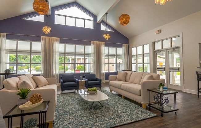 a living room with couches and chairs and a rug