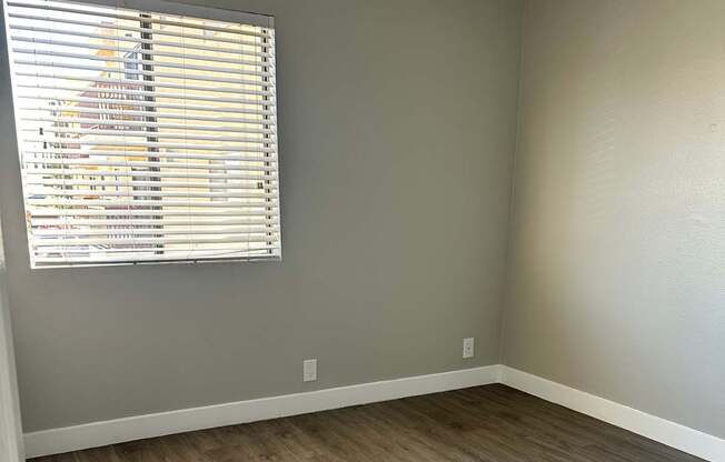 A room with a window covered by blinds.