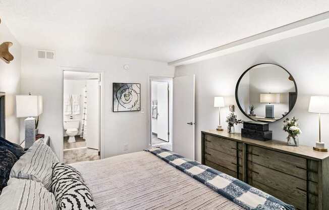 A bedroom with a bed, dresser, and mirror.