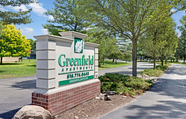 a sign at the entrance of greenfield apartments
