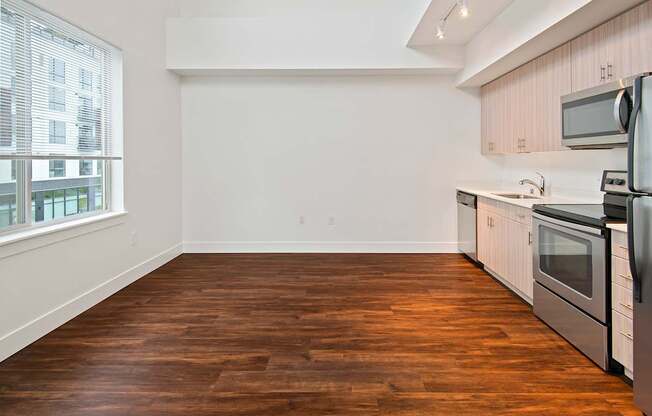 A kitchen with white cabinets and a wooden floor.