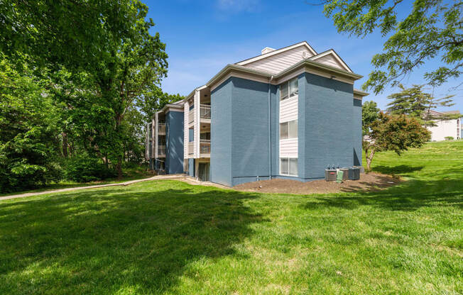 a blue building with grass and trees around it at Eastwood Crossings, Kansas City, MO, 64129