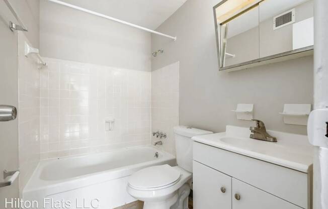 a white bathroom with a sink toilet and bath tub