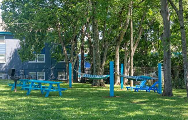 Nashville TN Apartments - The Canvas - Outdoor Hammock Lounge with Two Hammocks, Outdoor Grill Station, and Picnic Seating Surrounded By Lush Landscaping