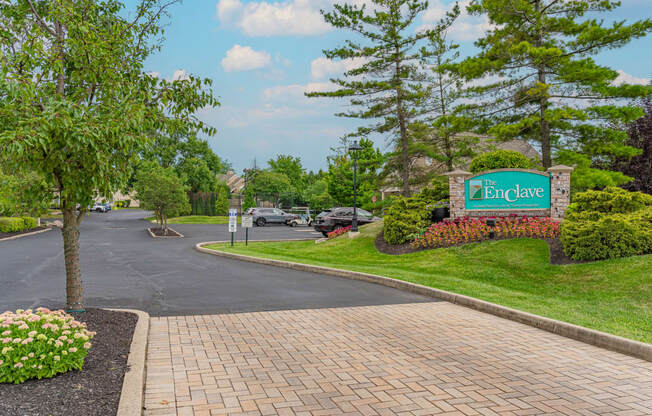 a view of the entrance sign at the enclave at woodbridge apartments in sugar land, tx