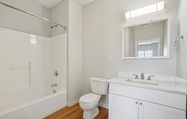 A white bathroom with a toilet, sink, and bathtub.