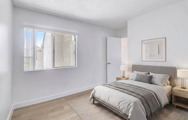 A bedroom with a large bed and a large window.