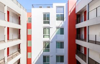 a row of apartment buildings with red and white balconies