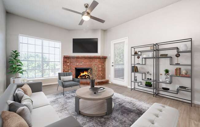 an open living room with a fireplace and a ceiling fan