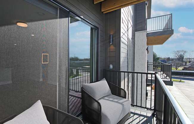 A balcony with a chair and a table.