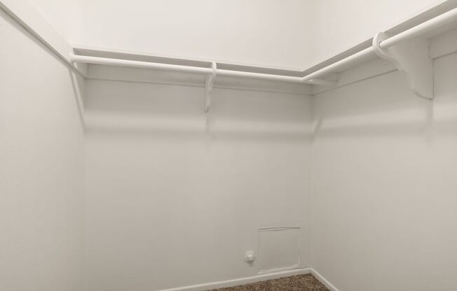 a white room with white walls and a white pipe on the ceiling