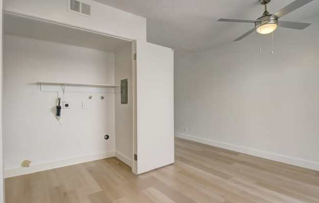 A room with a ceiling fan and a door.
