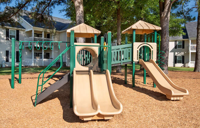 a playground with slides and swings in front of a house