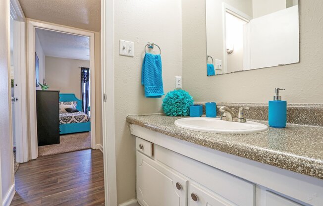 A bathroom with a white sink and blue towel at The Drake in Bossier City, LA