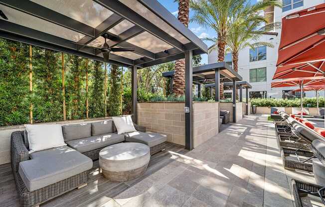 Shaded cabana seating with modern wicker furniture and ceiling fans for breezy afternoons by the pool