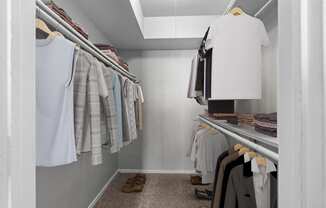 a walk in closet filled with clothes and shoes