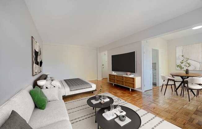 A modern living room with a grey sofa, a black coffee table, and a television.