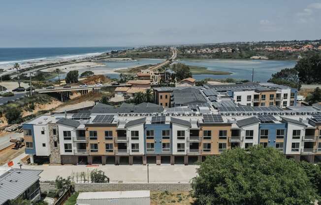 an aerial view of an apartment complex with the ocean in the background