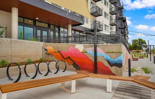 a bench with a mural on the side of a building