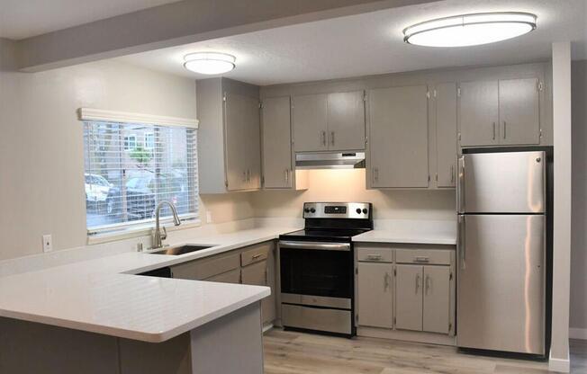 a kitchen with stainless steel appliances and white counter tops