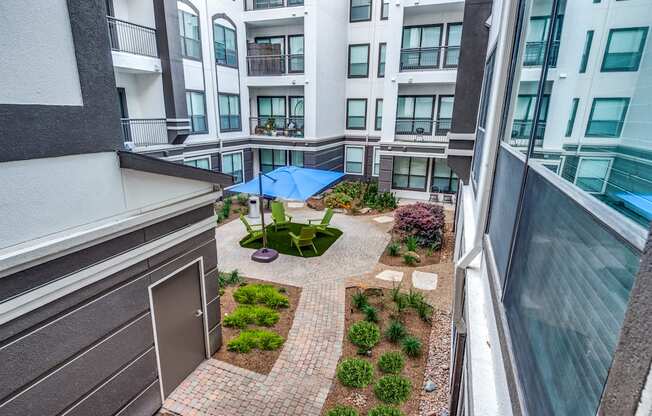 a view of a courtyard from a balcony of an apartment building