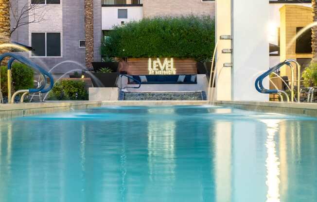 A pool with a slide and a building that says "LEVEL" in the background.