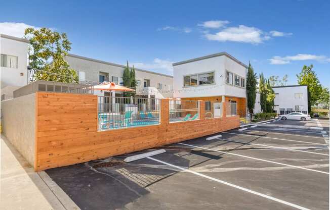 a wooden fence with a pool in the middle of a parking lot