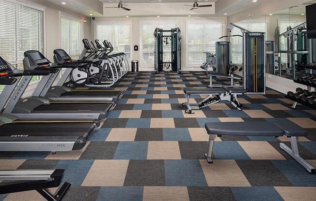 a gym with cardio machines and weights on a checkered floor at Promenade at Newnan Crossing, Newnan, 30265