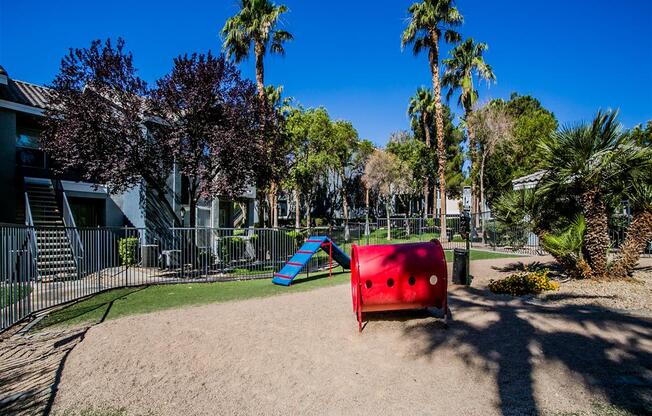 a playground with a red bench and a blue slide