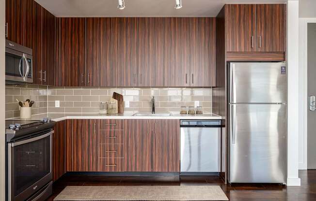 A modern kitchen with wooden cabinets and stainless steel appliances.