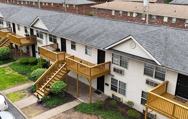 Apartment complex with a white building and a wooden deck.
