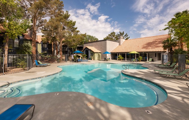 a large swimming pool with a house in the background