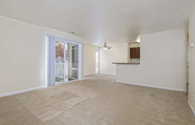 an empty living room with a door to a balcony