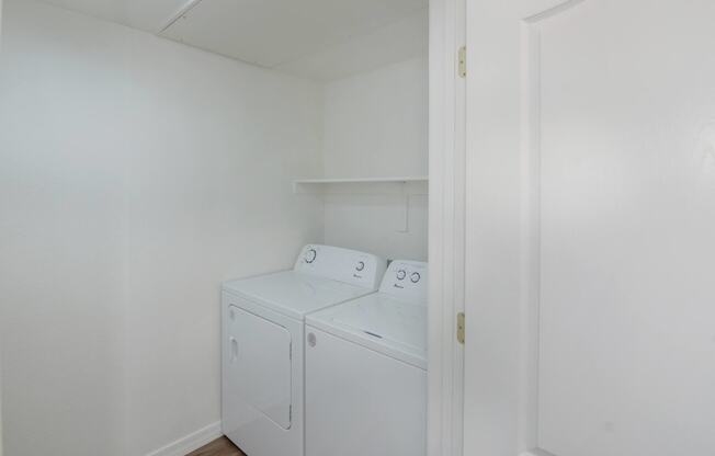 a small laundry room with a washer and dryer and white walls