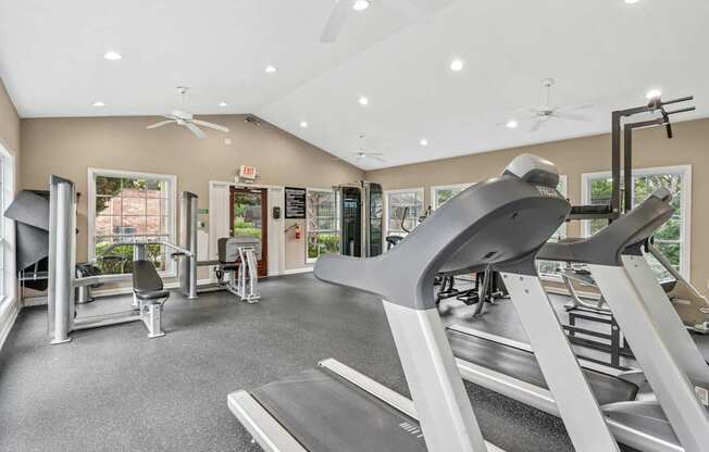 A gym with treadmills, weights, and exercise equipment.