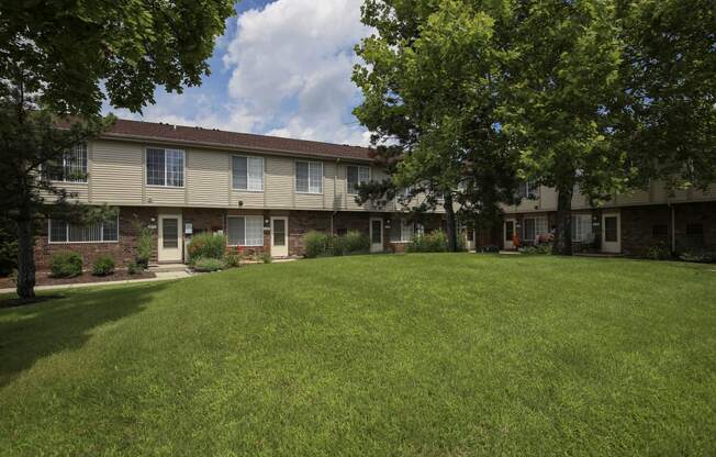 our apartments are located in a large grassy area with trees at Village Club of Rochester Hills, Shelby Township, MI