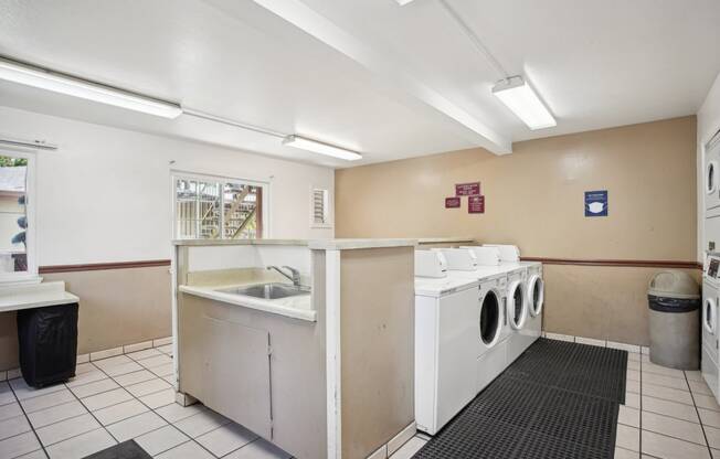 a laundry room with two washing machines and a sink