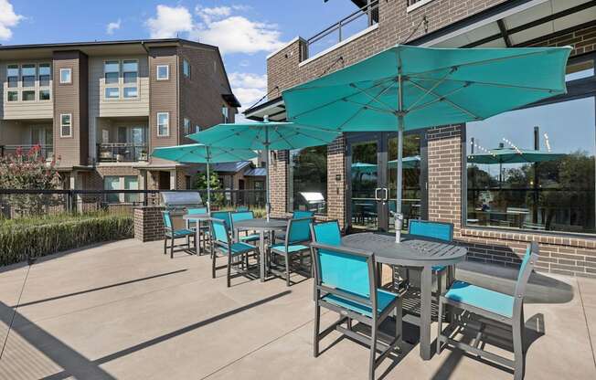 A patio with a table and chairs under a blue umbrella.