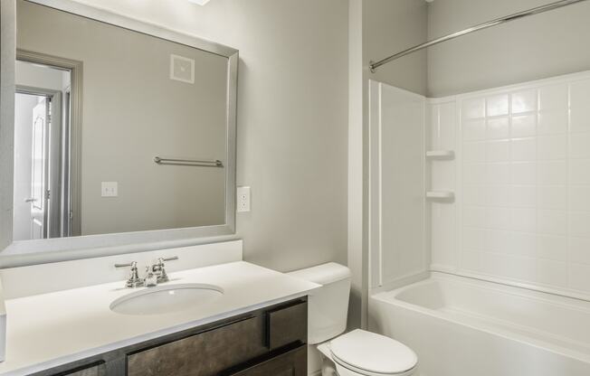 a bathroom with a sink toilet and shower and a mirror