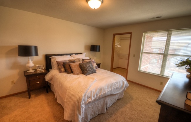 a bedroom with a large bed and a window