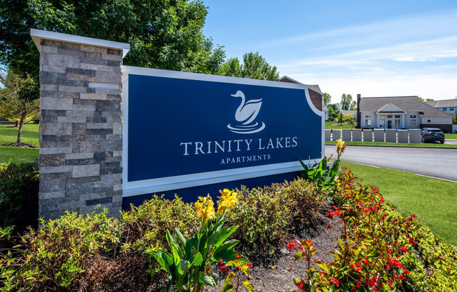 the sign for trinity lakes apartments at the entrance to the street