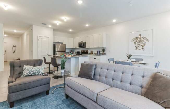 Boatman Hammock Townhomes in Lake Worth, FL photo of a living room with a couch and a chair and a kitchen